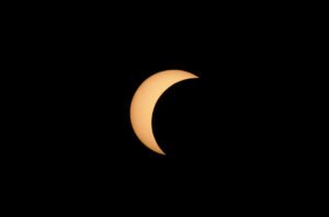A close-up astrophotography image of part of teh August 2026 solar eclipse, showing the dark silhouette of the Moon cutting deep into the orange solar disk. Captured from the rice fields of Pal;s, Girona Province, with Canon EOS Ra camera and 100-500mm Canon lens.