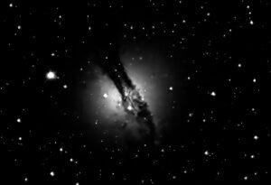 Centaurus A (NGC 5128), 12 million light-years distant; features dark dust across its centre, a remnant of a smaller spiral galaxy that merged with the larger elliptical galaxy about 450 million years ago, triggering intense star formation. The galaxy houses a very active supermassive black hole at its core and has intense radio emission lobes one million light-years wide. Collections: Galaxies _ Southern Celestial Hemisphere