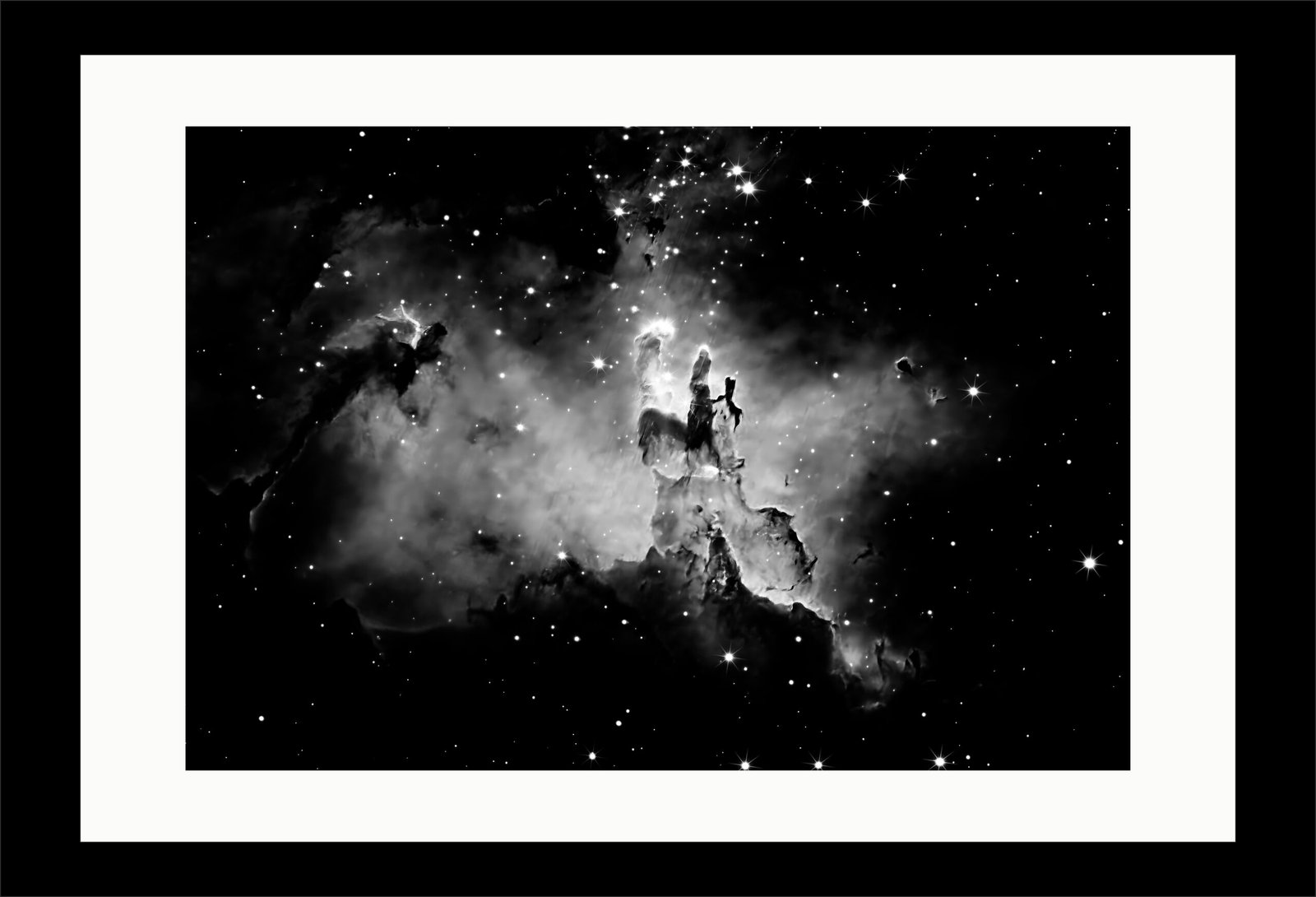 Bringing the cosmos into the living space. This gallery-mounted, monochrome presentation of the Pillars of Creation strips away color to focus entirely on raw structural contrast. The deep, dark nebular lanes and ionized gas borders are beautifully accentuated by a minimalist black frame and custom white matting
