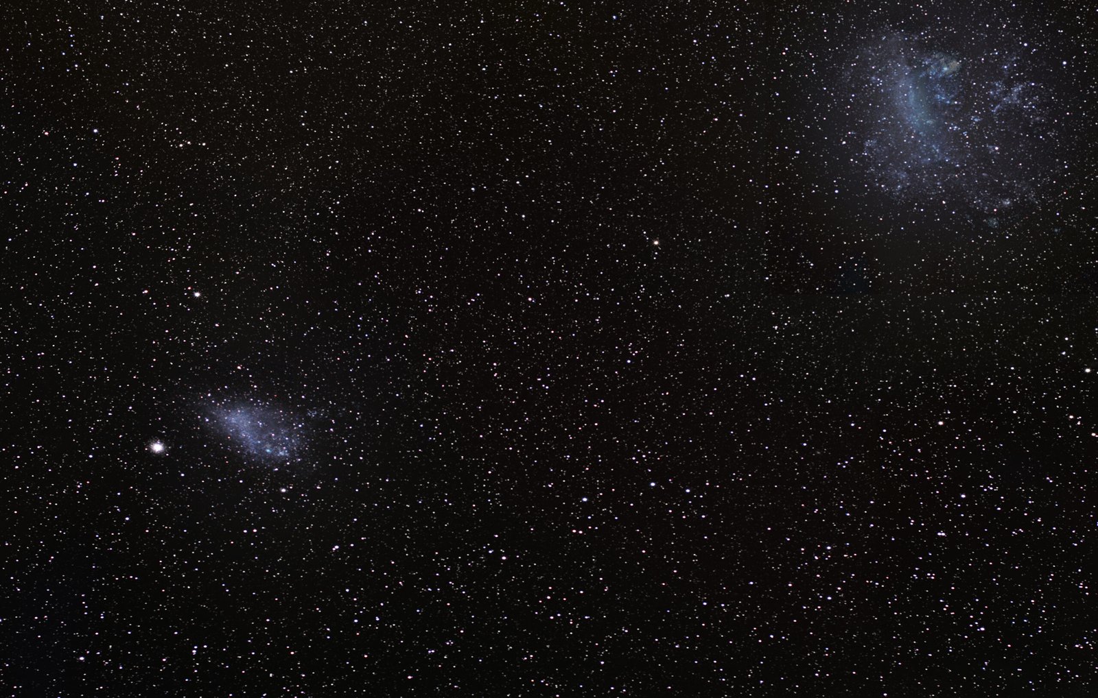 The dynamic duopoly of the southern sky. Framed together in a single ultra-wide perspective, the Large and Small Magellanic Clouds stand as the Milky Way's most prominent satellite galaxies. Located roughly 160,000 and 200,000 light-years away respectively, this deep-sky capture highlights their irregular cosmic structures and the vast intergalactic gap between them